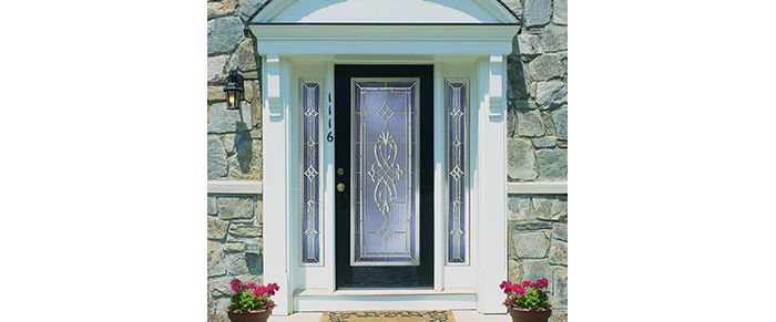 Columned front entry door with side panels and arched wood on top